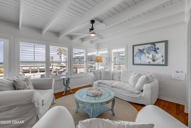 living room with baseboards, beamed ceiling, wood finished floors, and a ceiling fan