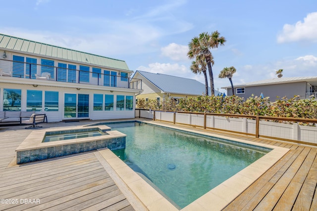 view of swimming pool featuring a pool with connected hot tub and fence