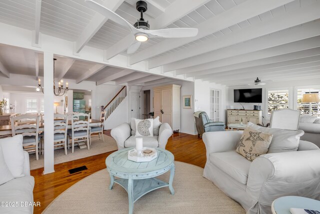 living area featuring ceiling fan with notable chandelier, a healthy amount of sunlight, and wood finished floors