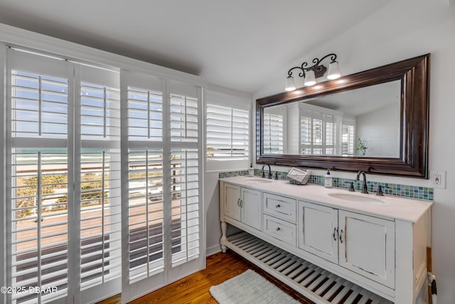 full bath with wood finished floors, a sink, and a healthy amount of sunlight
