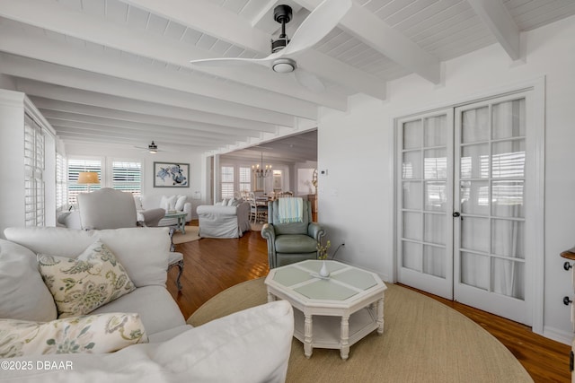 living room with beam ceiling, ceiling fan with notable chandelier, and wood finished floors