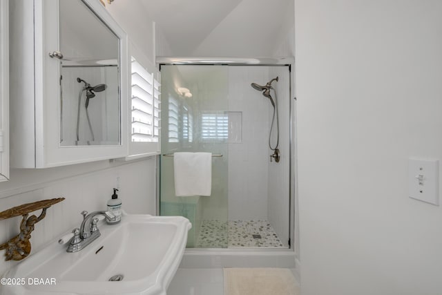 bathroom featuring a sink and a shower stall