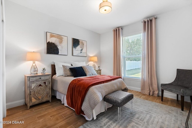 bedroom with hardwood / wood-style flooring and multiple windows