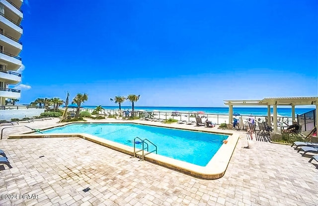 view of swimming pool featuring a water view and a patio area