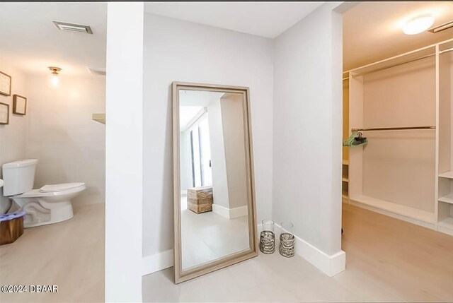 bathroom featuring wood-type flooring and toilet