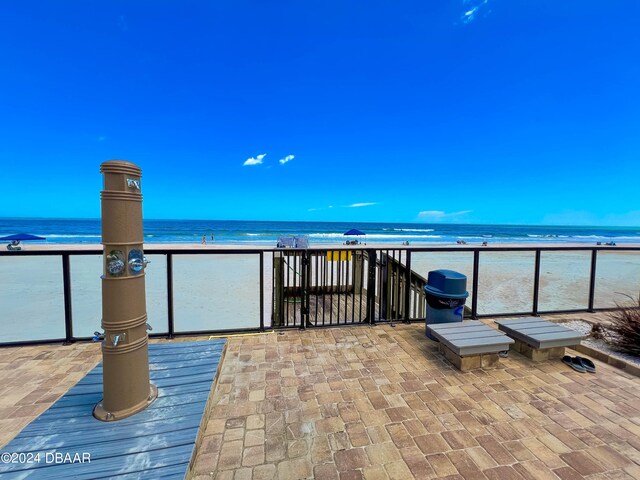 view of patio / terrace featuring a view of the beach, a water view, and a balcony