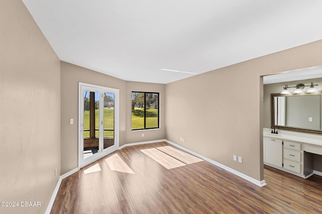 unfurnished room with sink and hardwood / wood-style floors