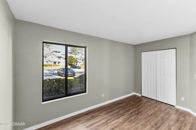 unfurnished bedroom featuring a closet and hardwood / wood-style floors