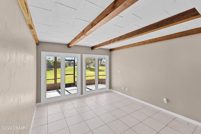 tiled spare room featuring french doors and beam ceiling