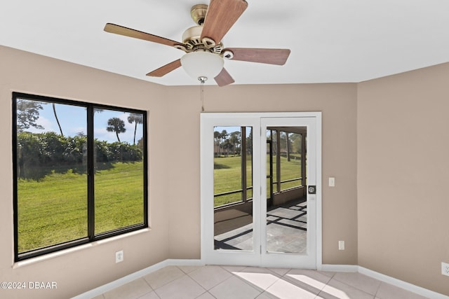 tiled spare room with ceiling fan