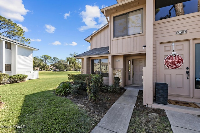 view of exterior entry with a lawn