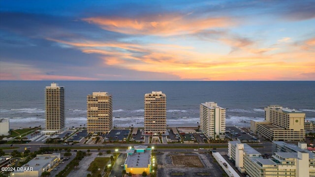 aerial view at dusk featuring a water view