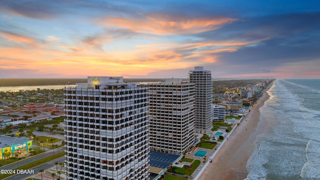 aerial view at dusk with a beach view and a water view