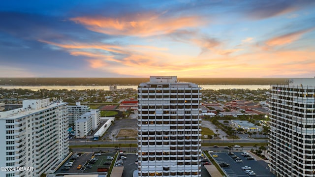 aerial view at dusk featuring a water view