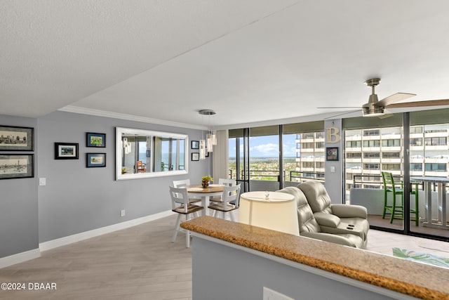 living room featuring a textured ceiling, floor to ceiling windows, ceiling fan, crown molding, and light wood-type flooring