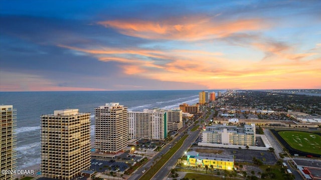 aerial view at dusk featuring a water view