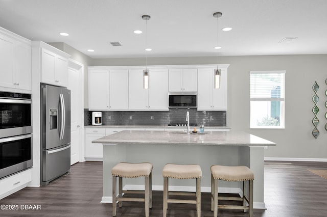 500 Barefoot Life Ln, Daytona Beach, FL 32124 - kitchen with appliances with stainless steel finishes, backsplash, dark wood-style flooring, a breakfast bar area, and recessed lighting