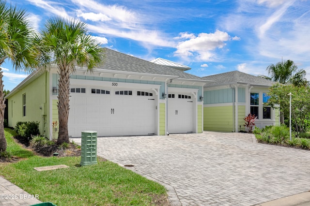500 Barefoot Life Ln, Daytona Beach, FL 32124 - view of front of home with an attached garage, decorative driveway, board and batten siding, and a shingled roof