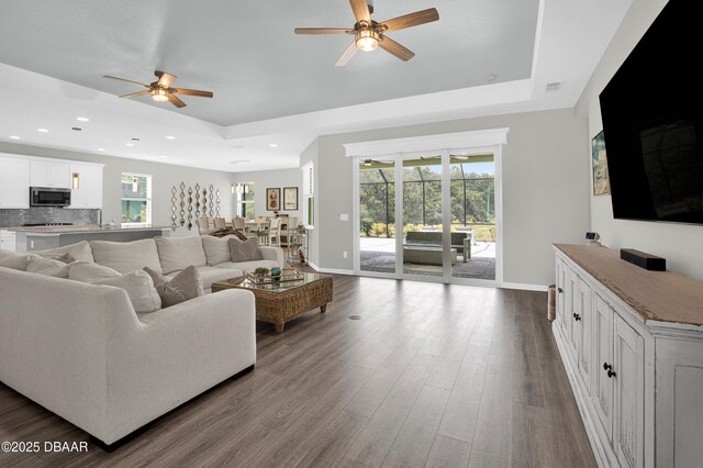 500 Barefoot Life Ln, Daytona Beach, FL 32124 - living room featuring ceiling fan, a tray ceiling, dark wood-style flooring, and recessed lighting