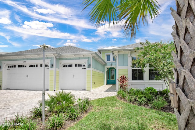 500 Barefoot Life Ln, Daytona Beach, FL 32124 - single story home featuring decorative driveway, a garage, board and batten siding, and a shingled roof