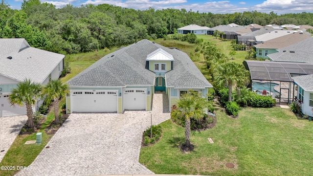500 Barefoot Life Ln, Daytona Beach, FL 32124 - view of front of house with a garage, decorative driveway, a front yard, a residential view, and glass enclosure