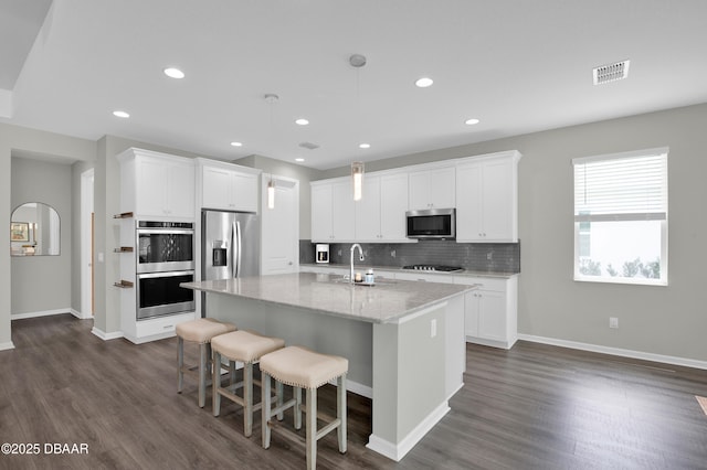 500 Barefoot Life Ln, Daytona Beach, FL 32124 - kitchen with stainless steel appliances, dark wood finished floors, backsplash, a kitchen island with sink, and recessed lighting