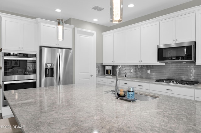 500 Barefoot Life Ln, Daytona Beach, FL 32124 - kitchen featuring appliances with stainless steel finishes, backsplash, white cabinetry, pendant lighting, and recessed lighting