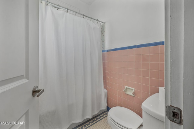 401 N Oleander Ave, Daytona Beach, FL 32118 - full bathroom featuring tile walls, toilet, and a wainscoted wall
