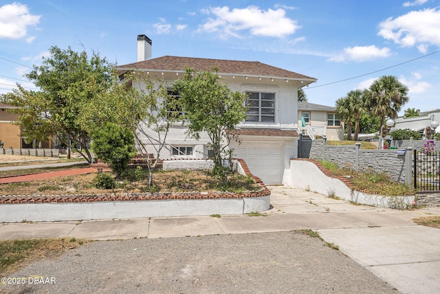 401 N Oleander Ave, Daytona Beach, FL 32118 - view of front of property with stairway, concrete driveway, fence, a garage, and a chimney
