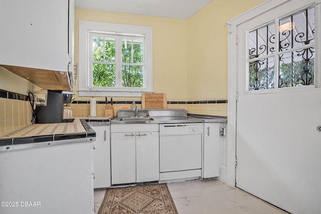 401 N Oleander Ave, Daytona Beach, FL 32118 - kitchen with dishwasher, stainless steel counters, white cabinets, light marble finish floors, and backsplash
