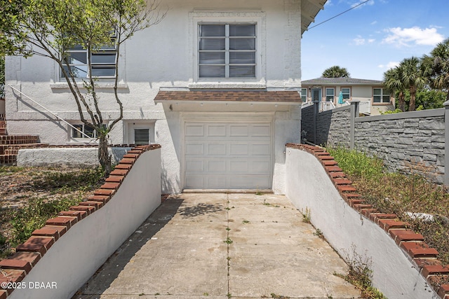 401 N Oleander Ave, Daytona Beach, FL 32118 - view of front facade featuring an attached garage, stucco siding, driveway, and fence