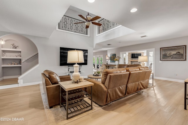 living room with light wood-type flooring and ceiling fan