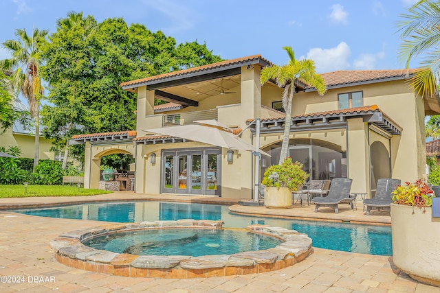 rear view of property with a pool with hot tub and a patio area