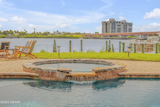 view of swimming pool featuring an in ground hot tub, a water view, and pool water feature