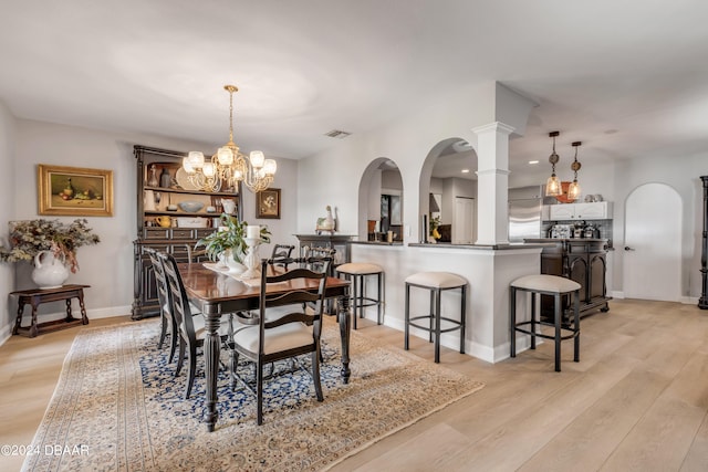 dining room featuring light wood-type flooring and a notable chandelier