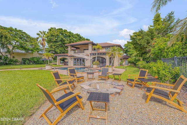 view of patio / terrace featuring a swimming pool with hot tub and an outdoor fire pit