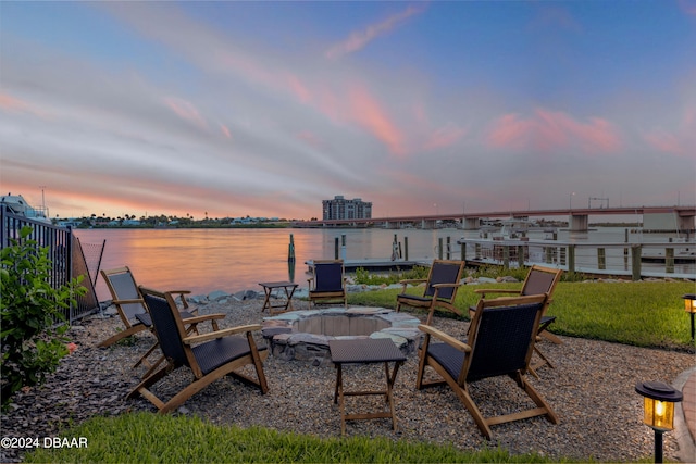 patio terrace at dusk featuring a water view