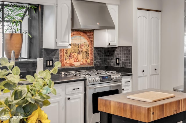 kitchen with white cabinetry, stainless steel range with gas cooktop, decorative backsplash, and wall chimney exhaust hood