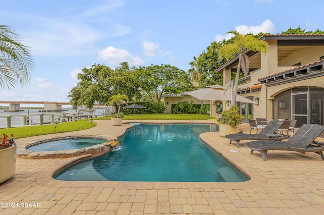 view of swimming pool featuring a patio, a lawn, and an in ground hot tub