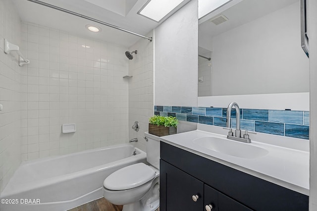bathroom with visible vents, tub / shower combination, toilet, wood finished floors, and vanity