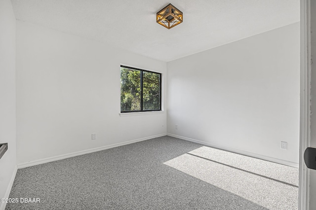 unfurnished room with carpet and baseboards
