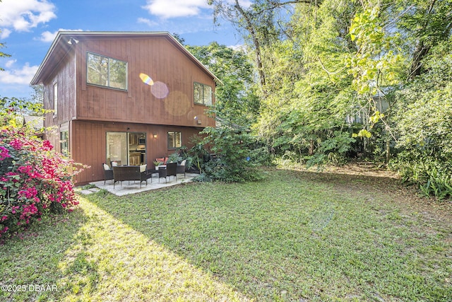 back of house featuring a lawn and a patio area