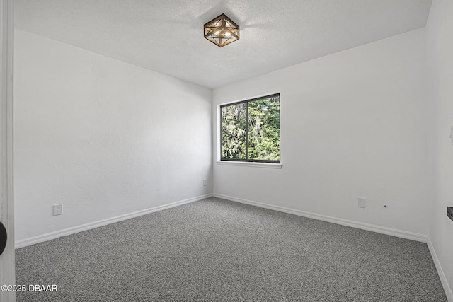 unfurnished room featuring a textured ceiling, carpet, and baseboards