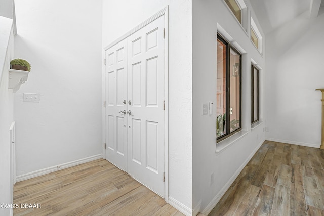 hall with baseboards and wood finished floors