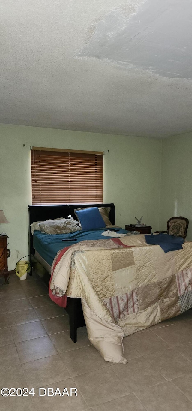 tiled bedroom with a textured ceiling