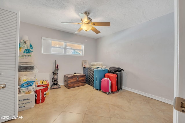 game room featuring ceiling fan, a textured ceiling, and light tile patterned floors