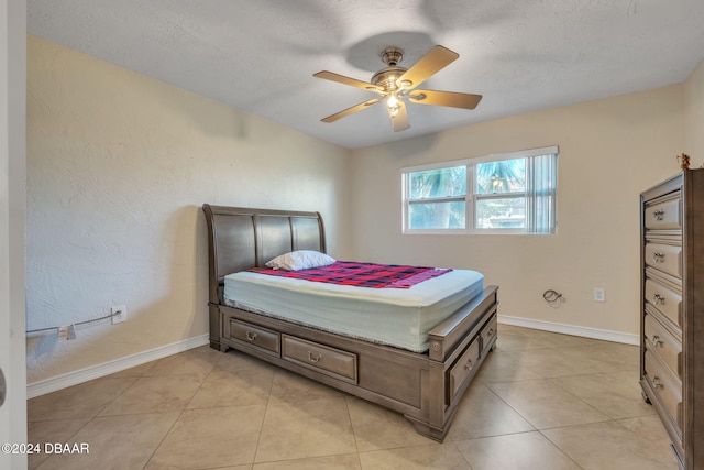 tiled bedroom featuring ceiling fan and a textured ceiling