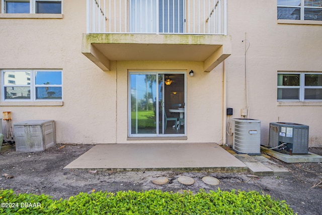 entrance to property with cooling unit, a balcony, and a patio area