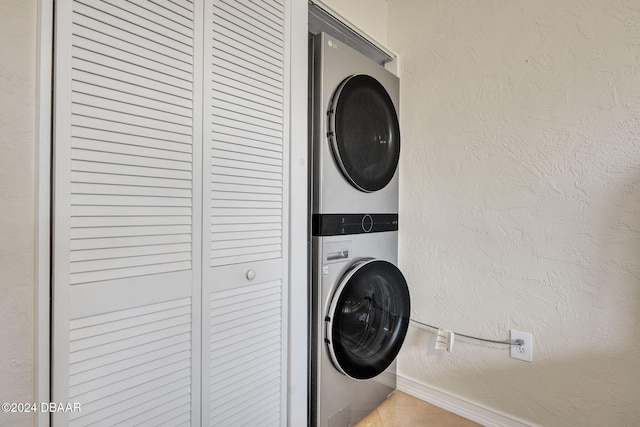 laundry room with light tile patterned floors and stacked washer and dryer