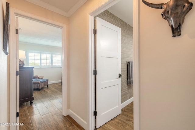 hallway with crown molding, baseboards, and wood finished floors